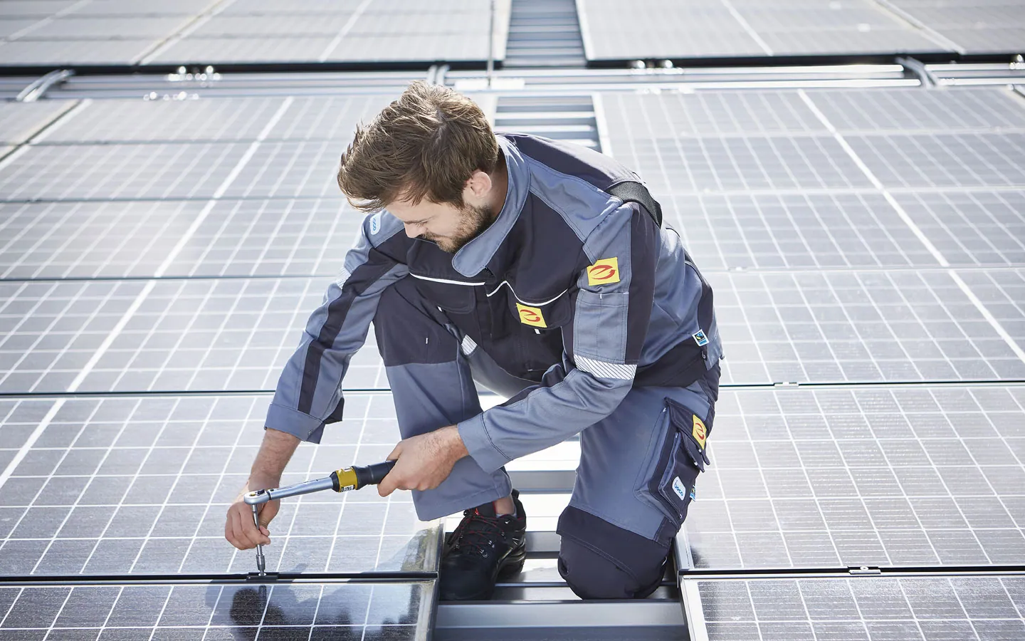 E-CHECK E-Mobilität - Mitarbeiter montiert auf dem Dach die neuen Solarmodule · Degen