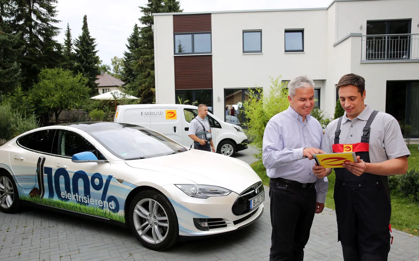 E-Mobilität - Mitarbeiter mit Kunden vor Elektrofahrzeugen 100% elektrisch · Degen